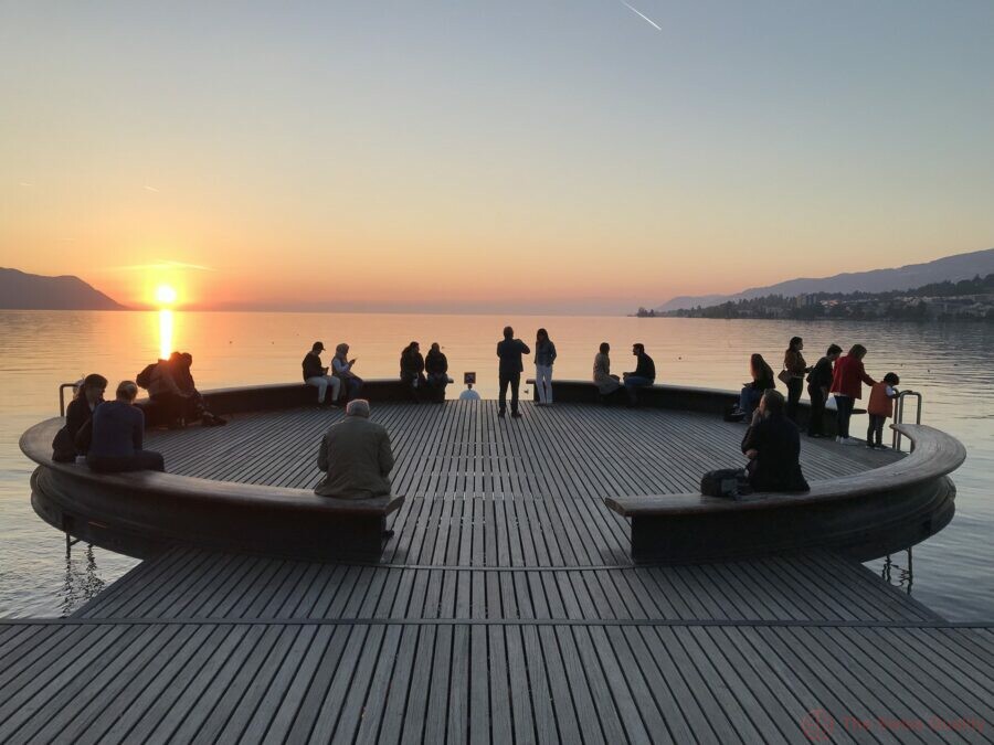 candid photo of people enjoying sunset view at lake geneva
