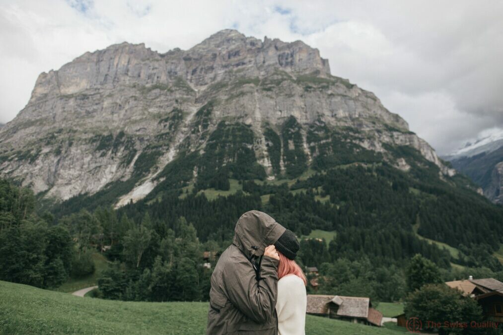 side view of young couple in love hugging and mountain landscape behind bern switzerland