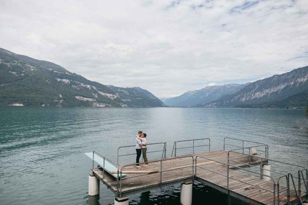 young couple in love hugging on wooden pier in mountain lake bern switzerland