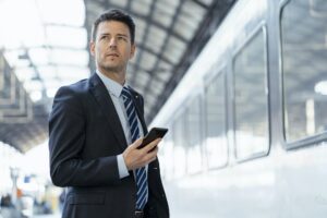 Change Management - businessman with cell phone on station platform