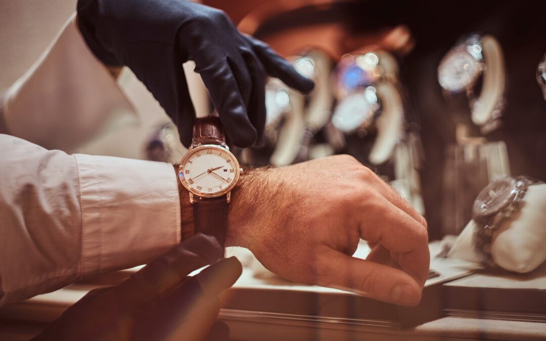 close up hands assistant helps the client to try on exclusive men s watches