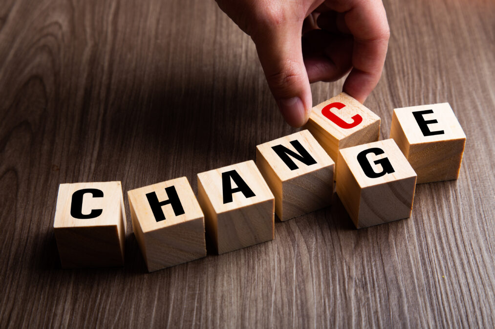 Change Management: Hand changing wooden cube with word change to chance,.
