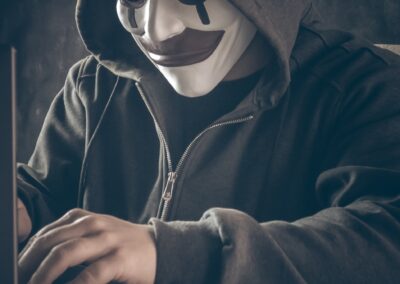 a person wearing a mask using a laptop